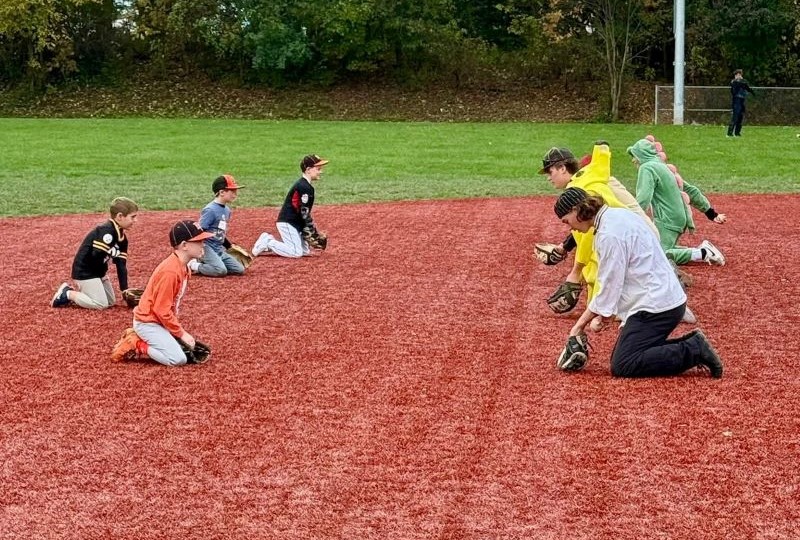 Players working on hitting drills at a clinic