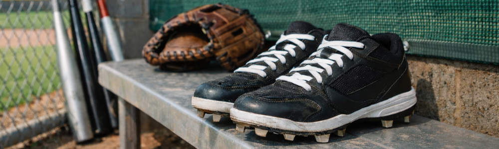 dugout with cleats, glove and bats