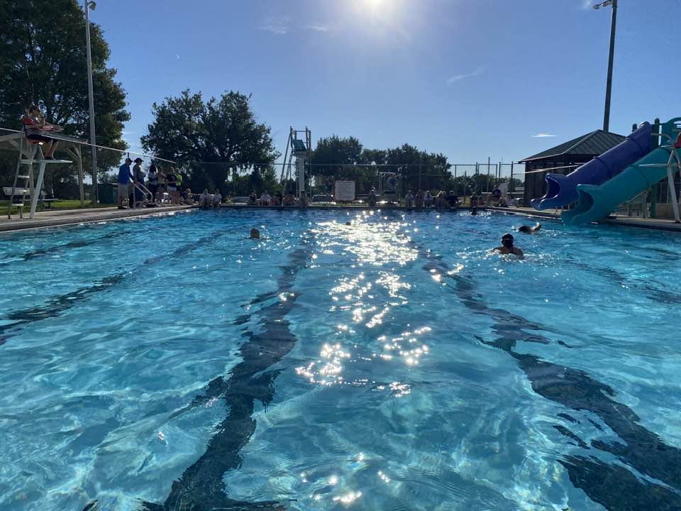 a swimming pool with sunlight gleaming off the water